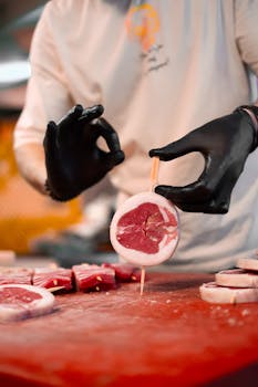 pexels photo 31612177 31612177 A butcher skillfully preparing fresh red meat slices with precision in a kitchen setting.