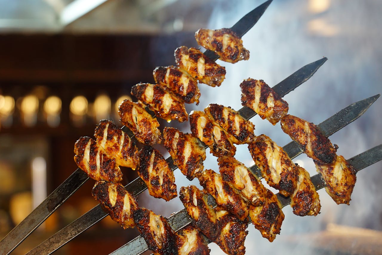 Juicy grilled chicken wings on skewers, perfect for a barbecue meal.